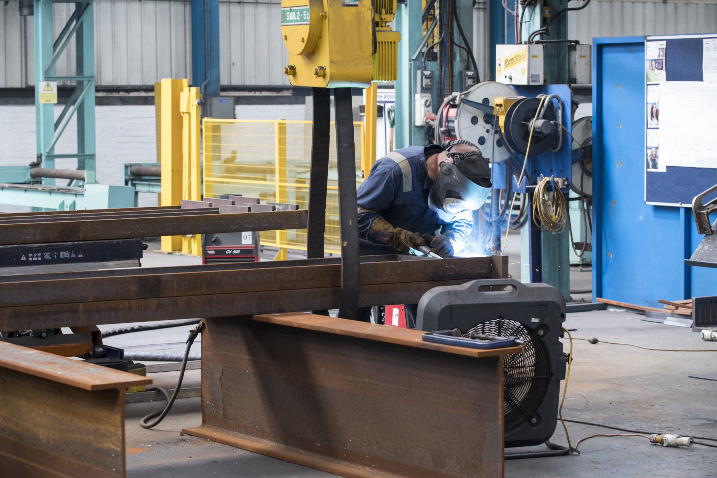 Welder fabricating structural steel in a workshop